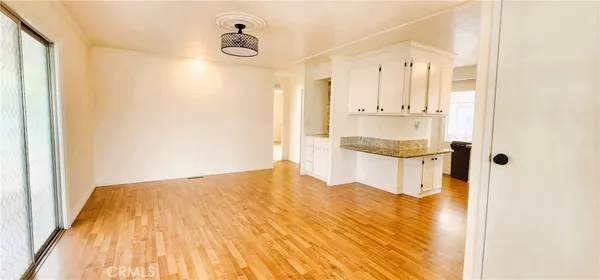 a view of walk in closet and bedroom with wooden floor