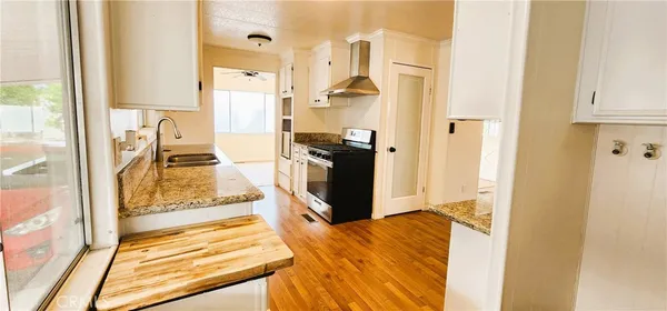 a walk in closet with wooden floor