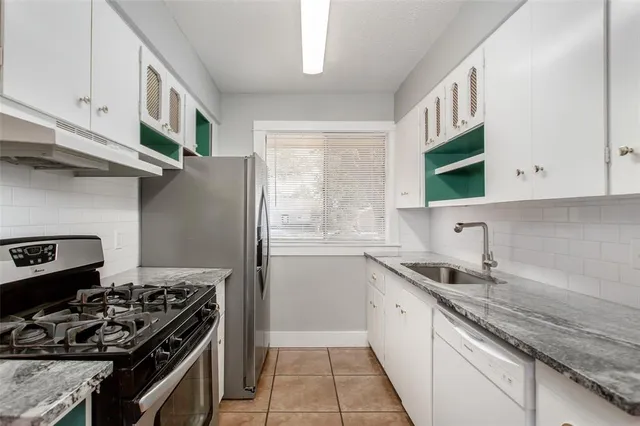 a kitchen with stainless steel appliances granite countertop a stove and a refrigerator