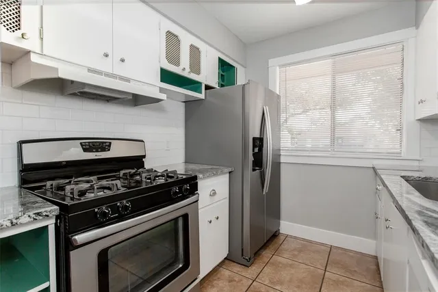 a kitchen with stainless steel appliances granite countertop a stove and a refrigerator