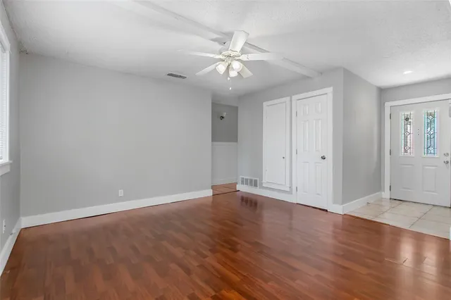 a view of an empty room with wooden floor