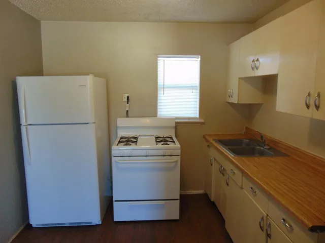 a kitchen with a stove a refrigerator and a sink