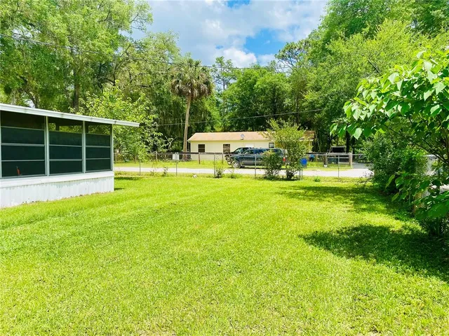 a backyard of a house with garden and trees