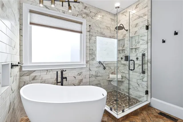 a white bath tub sitting next to a bathroom sink