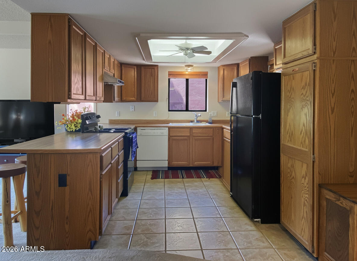550 Barcelona Road Sedona, AZ 86336 - Photo 13 of 32 a kitchen with a sink refrigerator and cabinets