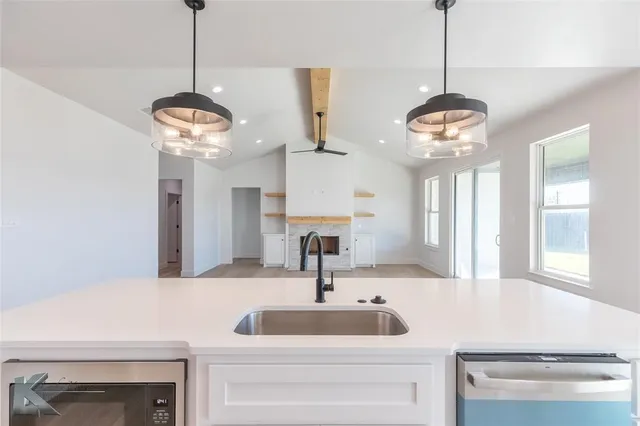 an empty room with wooden floor ceiling fan and windows