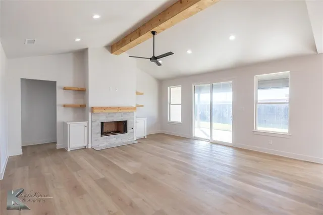 a large kitchen with a lot of counter space and wooden floor