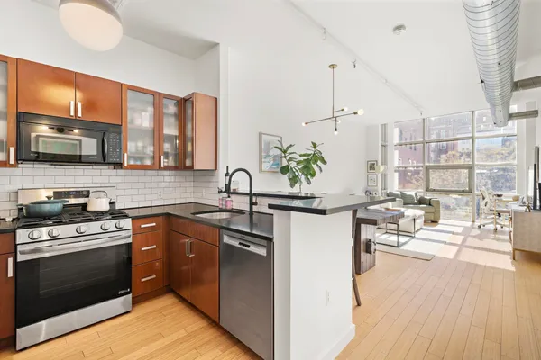 a kitchen with kitchen island granite countertop a sink cabinets and stainless steel appliances