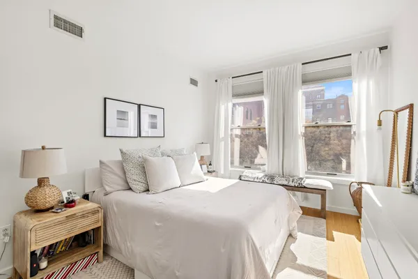 a bedroom with a bed and large windows