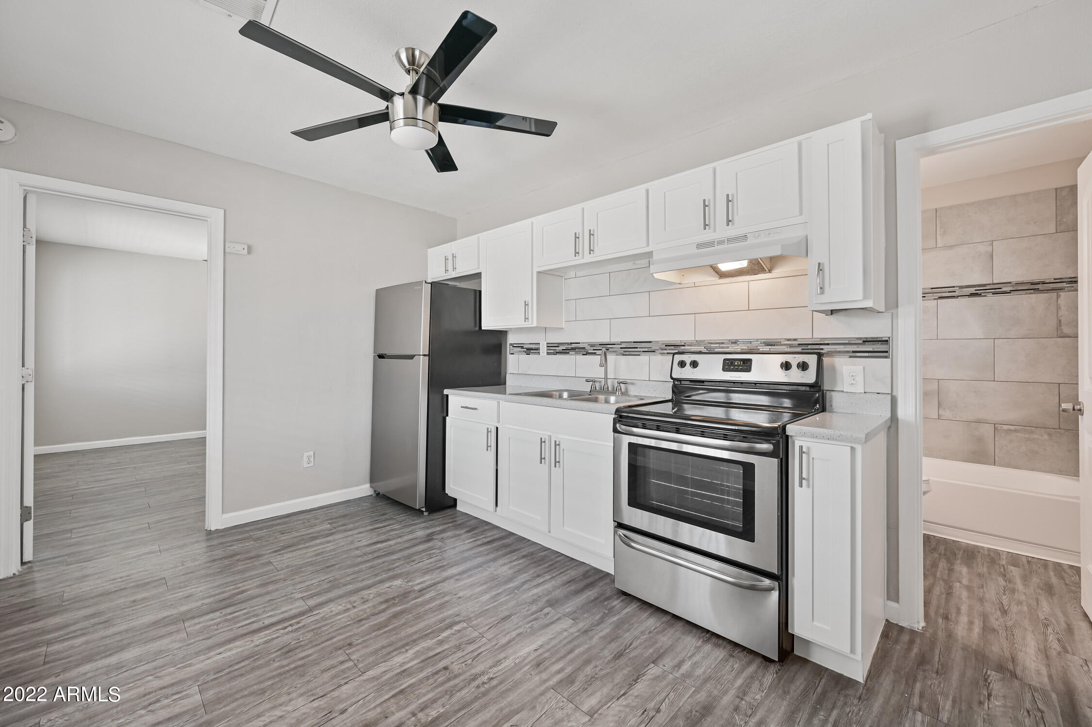 1744 West Glendale Avenue, Unit 1 Phoenix, AZ 85021 - Photo 4 of 12 a kitchen with stainless steel appliances a stove a refrigerator and white cabinets