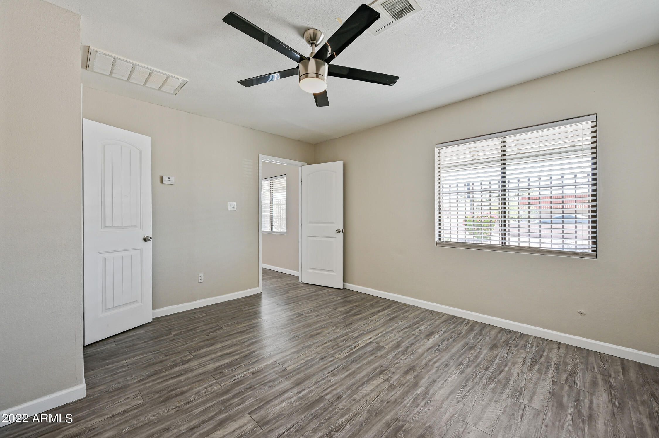 1744 West Glendale Avenue, Unit 1 Phoenix, AZ 85021 - Photo 10 of 12 a view of an empty room with window and wooden floor