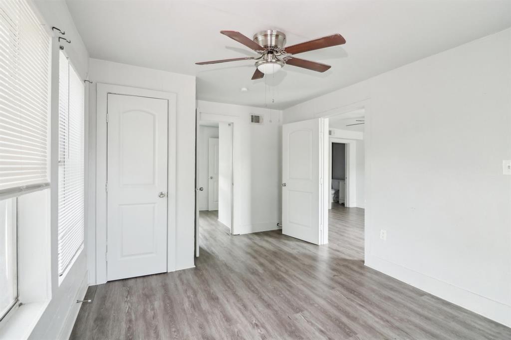 1906 Grainger Street Fort Worth, TX 76110 - Photo 11 of 38 Unfurnished bedroom featuring multiple windows, light wood-type flooring, and ceiling fan