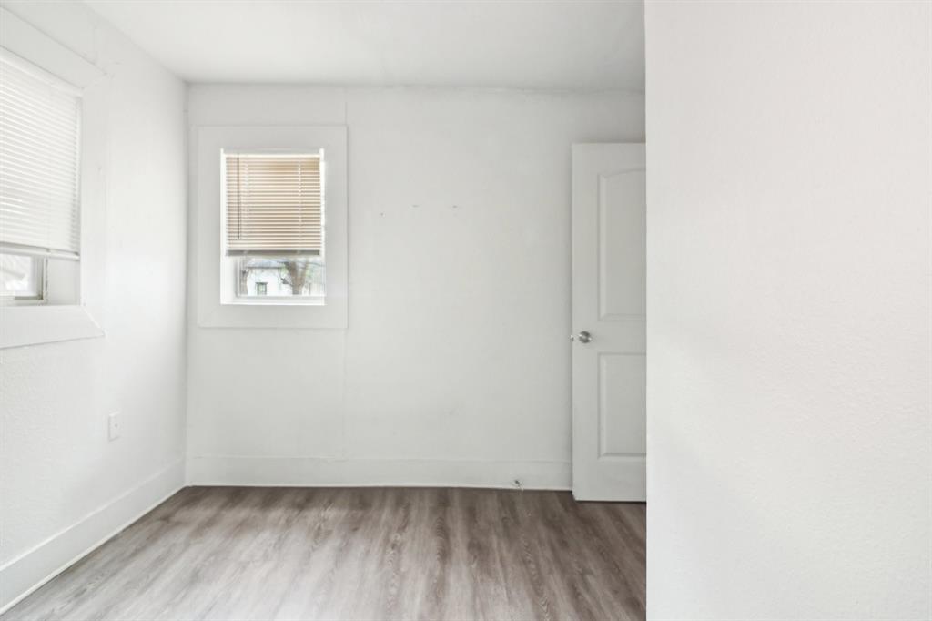 1906 Grainger Street Fort Worth, TX 76110 - Photo 15 of 38 Spare room featuring hardwood / wood-style flooring and a healthy amount of sunlight
