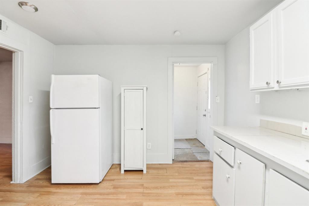 1906 Grainger Street Fort Worth, TX 76110 - Photo 21 of 38 Kitchen featuring white refrigerator, white cabinetry, and light hardwood / wood-style flooring