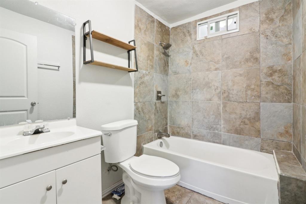 1906 Grainger Street Fort Worth, TX 76110 - Photo 34 of 38 Full bathroom featuring tile patterned flooring, vanity, toilet, and tiled shower / bath