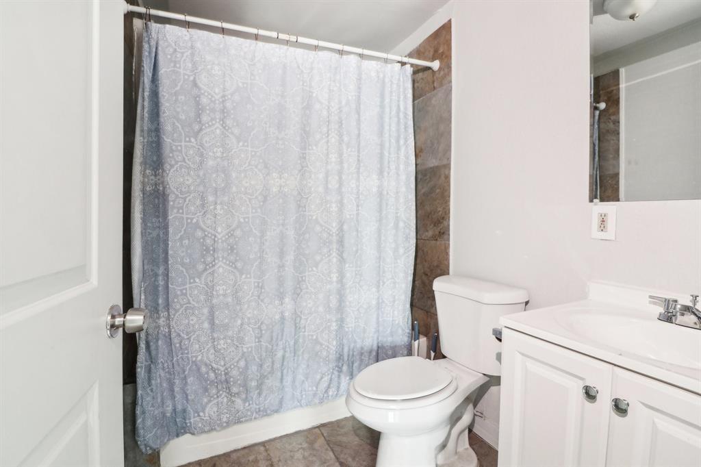 1906 Grainger Street Fort Worth, TX 76110 - Photo 8 of 38 Full bathroom with tile patterned floors, vanity, toilet, and shower / bath combination with curtain