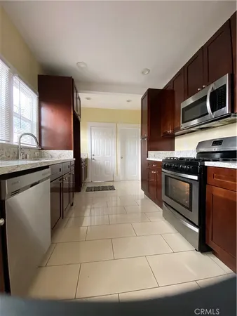 a kitchen with stainless steel appliances granite countertop a stove a sink and a microwave