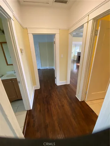 a view of a hallway with wooden floor and stairs