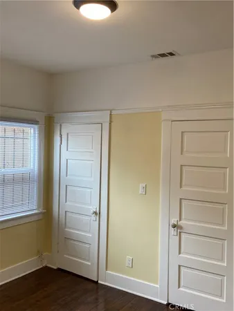 a view of an empty room and wooden floor and closet
