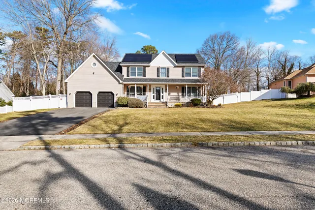 a view of a house with a yard and trees around