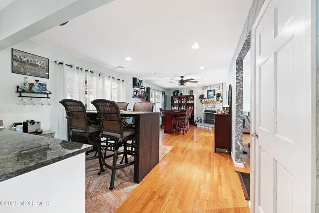 a dining hall with stainless steel appliances granite countertop a table chairs and a refrigerator