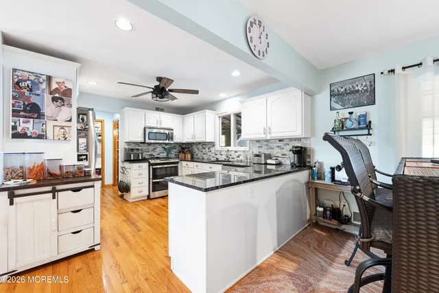 a kitchen with stainless steel appliances kitchen island granite countertop a stove and cabinets
