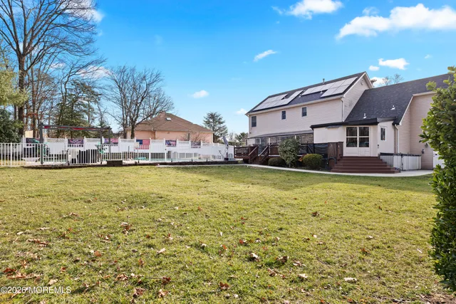 a large pool with lawn chairs under an umbrella