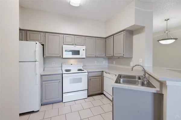 a kitchen with white cabinets sink and white appliances