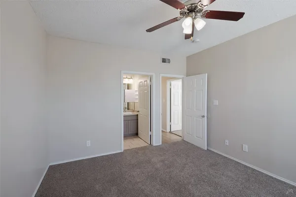 an empty room with closet and a chandelier fan
