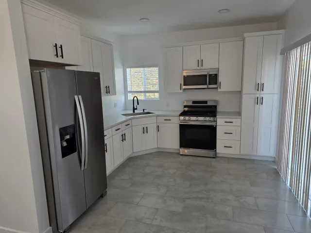 a kitchen with stainless steel appliances a refrigerator stove and microwave