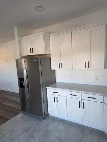 a kitchen with cabinets and a refrigerator