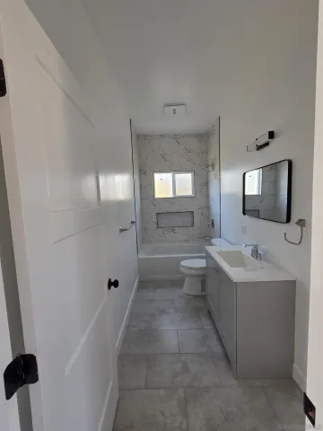 a bathroom with a tub sink and mirror