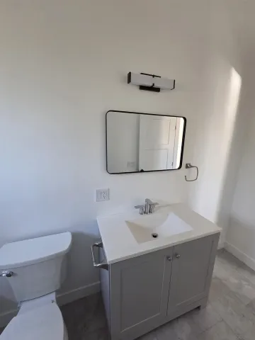 a bathroom with a toilet sink and mirror