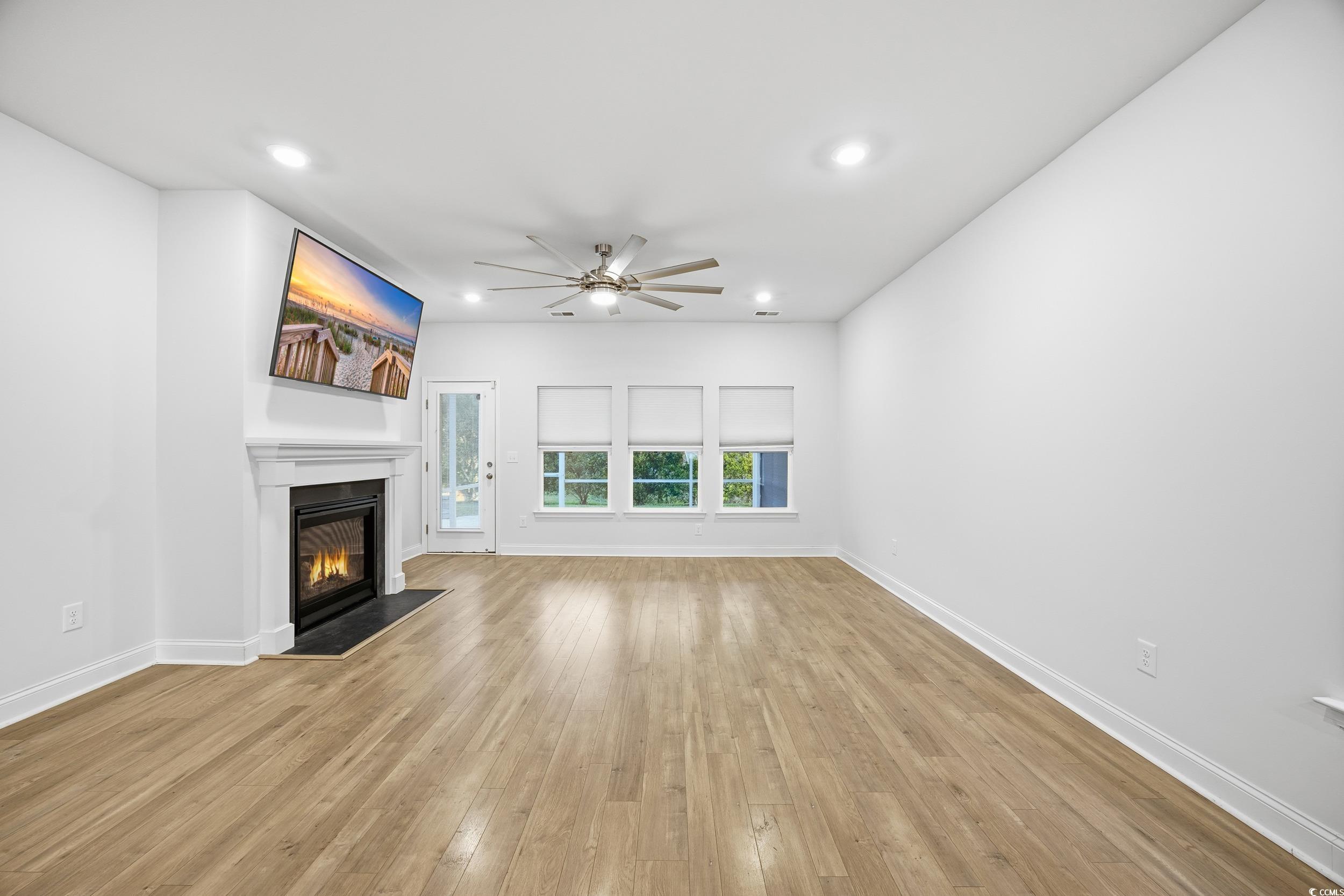 386 Harbison Circle Myrtle Beach, SC 29579 - Photo 12 of 34 Unfurnished living room featuring light wood finished floors, recessed lighting, a glass covered fireplace, and ceiling fan