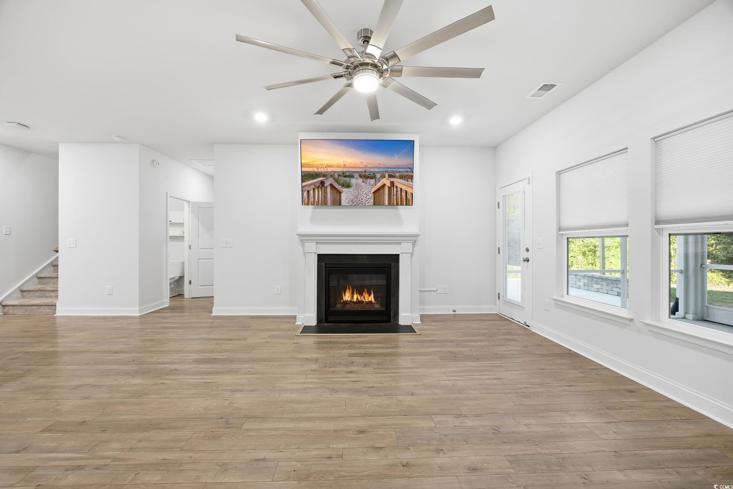 386 Harbison Circle Myrtle Beach, SC 29579 - Photo 13 of 34 Unfurnished living room featuring recessed lighting, light wood finished floors, a fireplace with flush hearth, a ceiling fan, and stairway