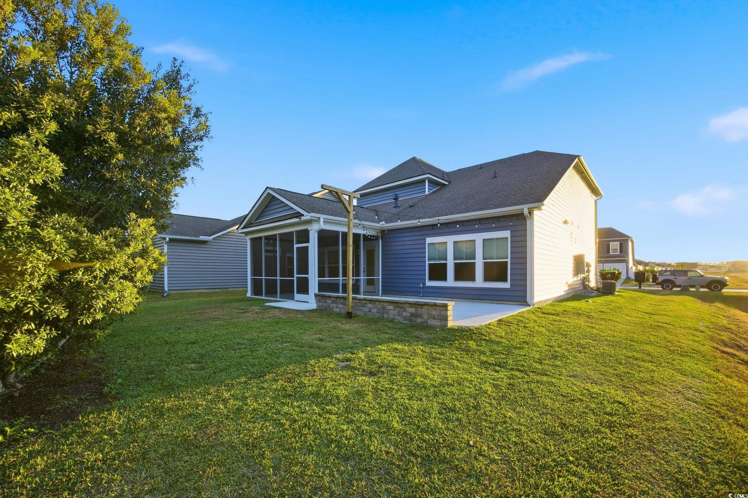 386 Harbison Circle Myrtle Beach, SC 29579 - Photo 35 of 40 Rear view of house featuring a lawn, a sunroom, a patio area, and roof with shingles