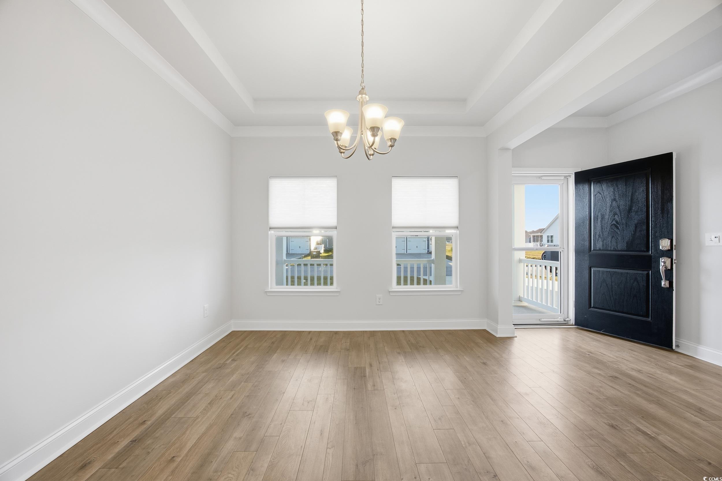 386 Harbison Circle Myrtle Beach, SC 29579 - Photo 6 of 34 Entryway featuring light wood-style flooring, a raised ceiling, a chandelier, and crown molding