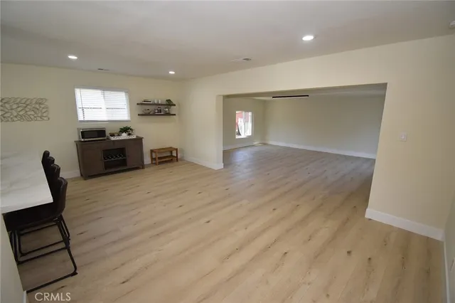 a view of a living room a dining room wooden floor and a window
