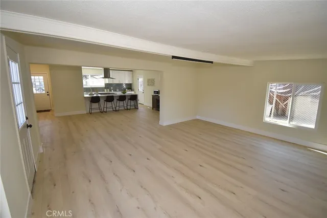 an empty room with wooden floor and a window