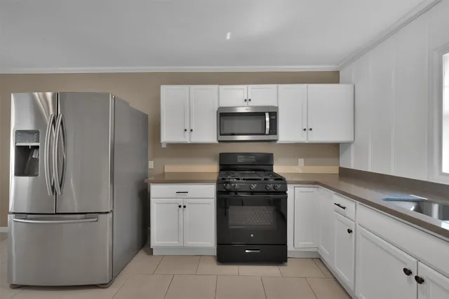 a kitchen with white cabinets and stainless steel appliances