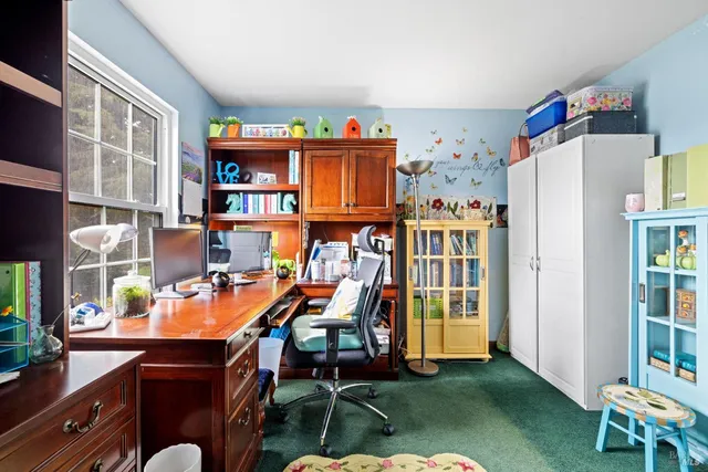 a view of a hallway with a dining table & chairs