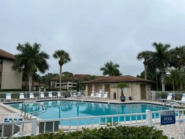 a view of a house with pool and chairs