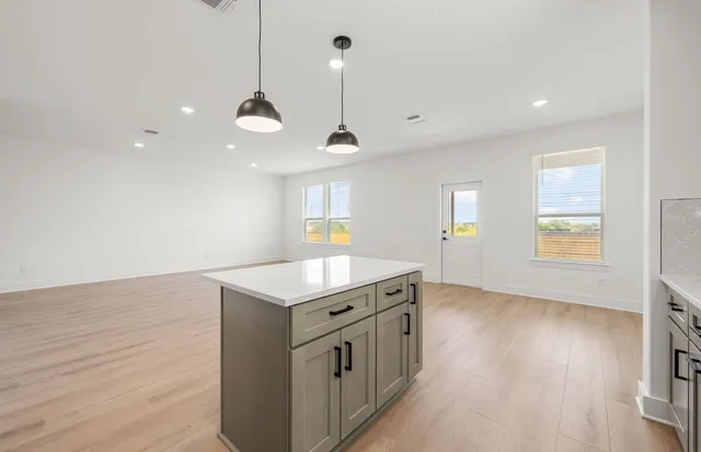 a kitchen with stainless steel appliances sink a stove and cabinets