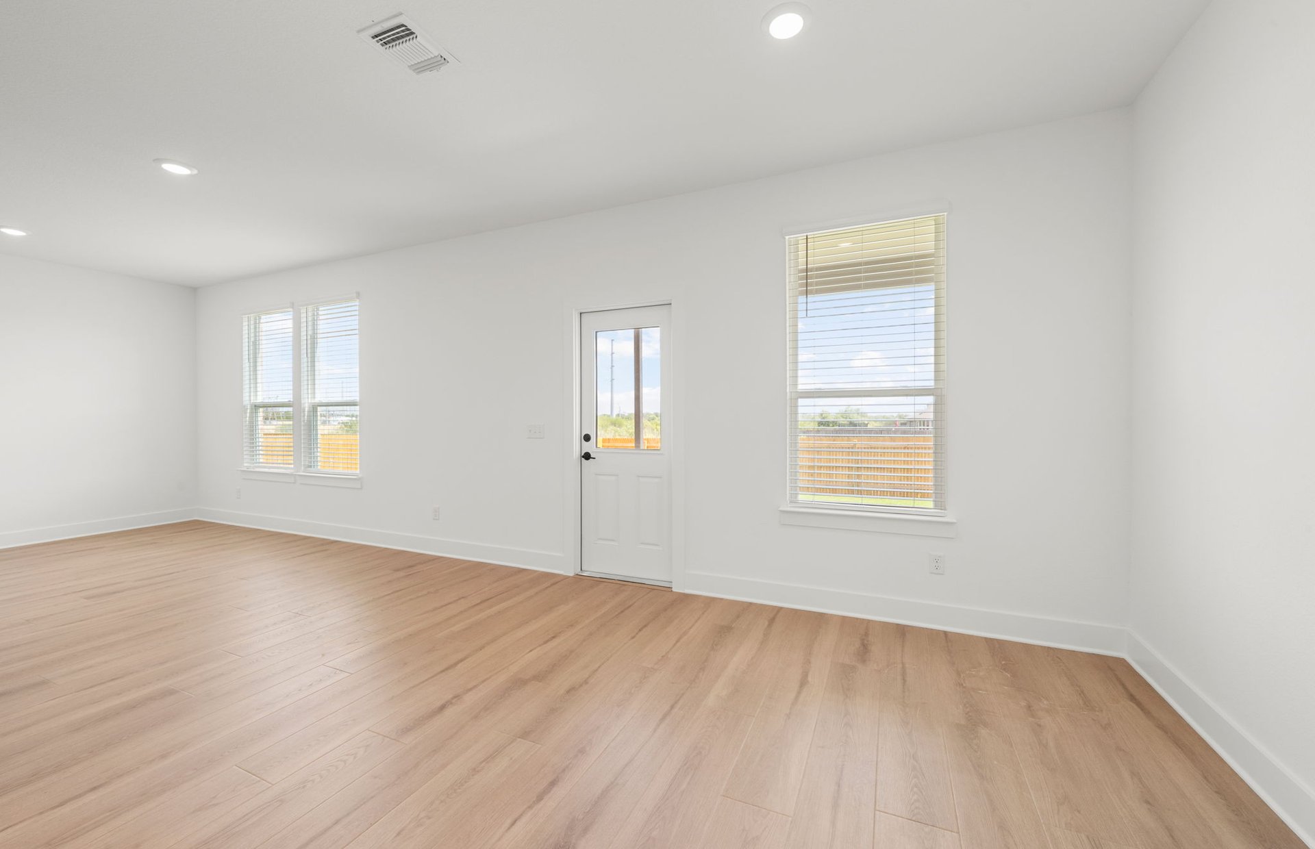 560 Tailwind Drive Kyle, TX 78640 - Photo 11 of 37 an empty room with wooden floor and windows