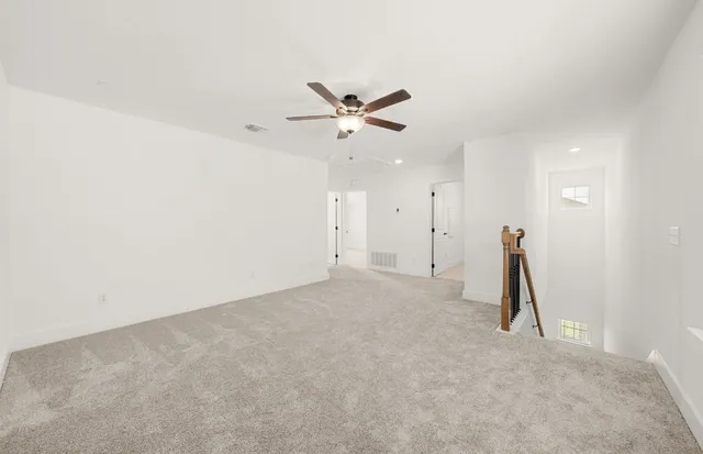 an empty room with closet and a ceiling fan