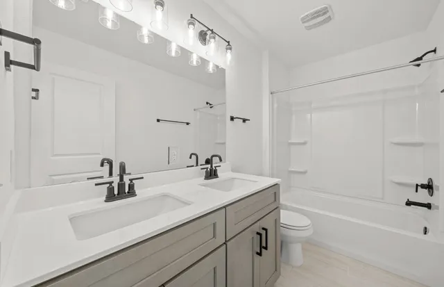 a bathroom with a sink a toilet a shower and a mirror