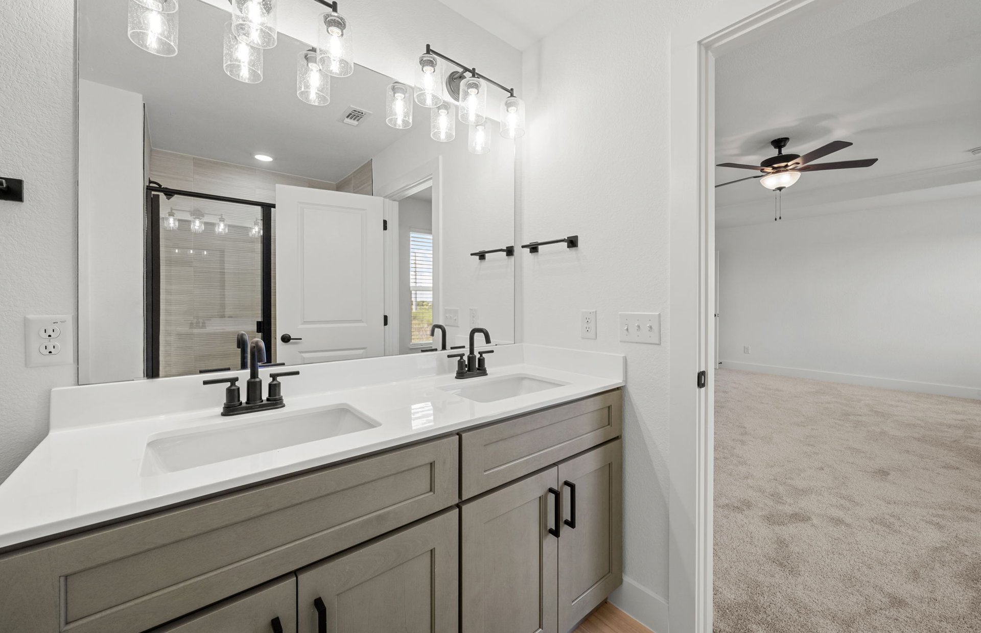 560 Tailwind Drive Kyle, TX 78640 - Photo 31 of 37 a bathroom with a sink a vanity a mirror and shower