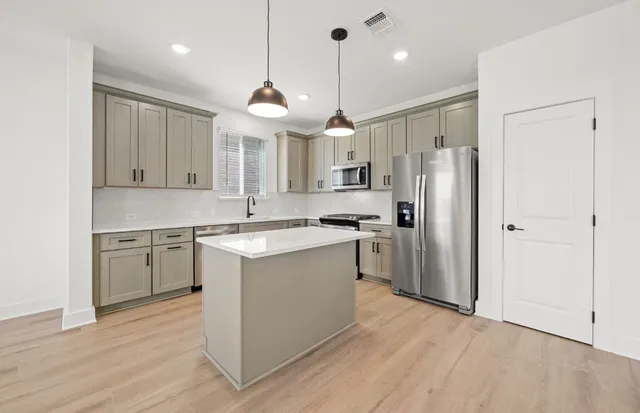 a kitchen with kitchen island a sink stainless steel appliances and window