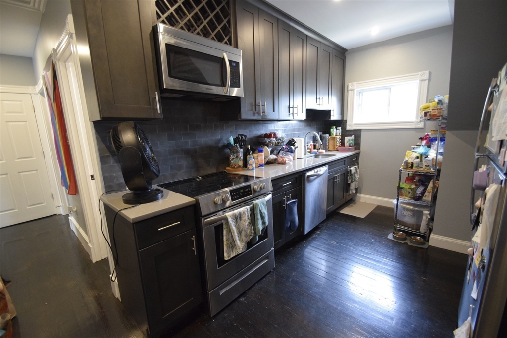 33-35 Ridgemont Street, Unit 3 Boston, MA 02134 - Photo 3 of 12 a kitchen with stainless steel appliances granite countertop a stove a sink and a refrigerator