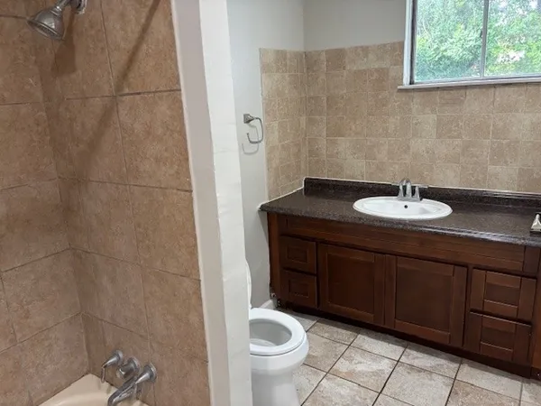 a bathroom with a granite countertop sink a toilet and a mirror